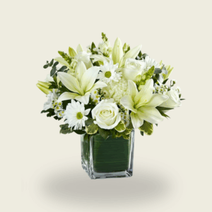 White lily and rose condolence flower arrangement in glass cube vase