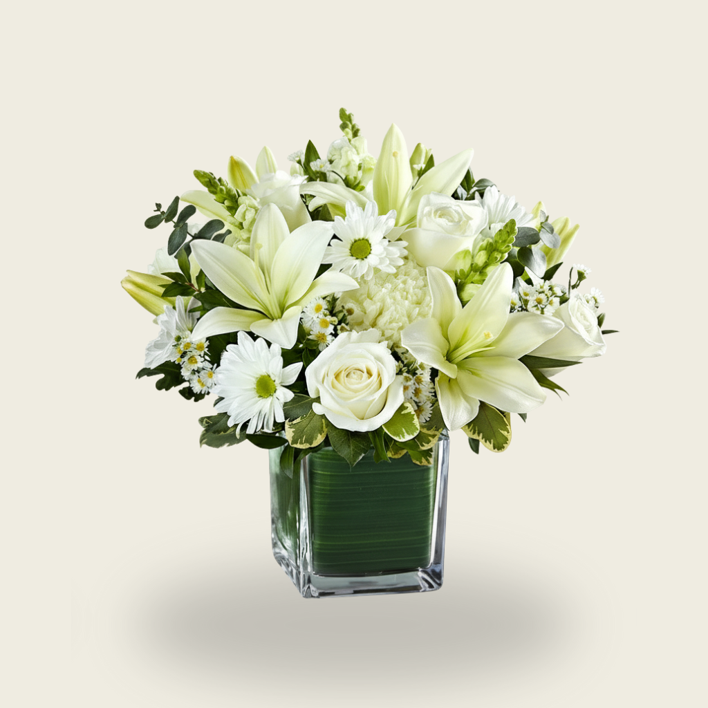 White lily and rose condolence flower arrangement in glass cube vase