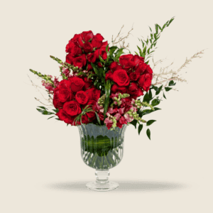 Dramatic vase arrangement of red roses with snapdragons and greens