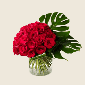 Modern vase arrangement of red roses with monstera leaf accent