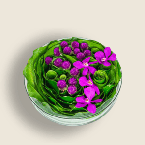 Low bowl arrangement with purple orchids and gomphrena flowers