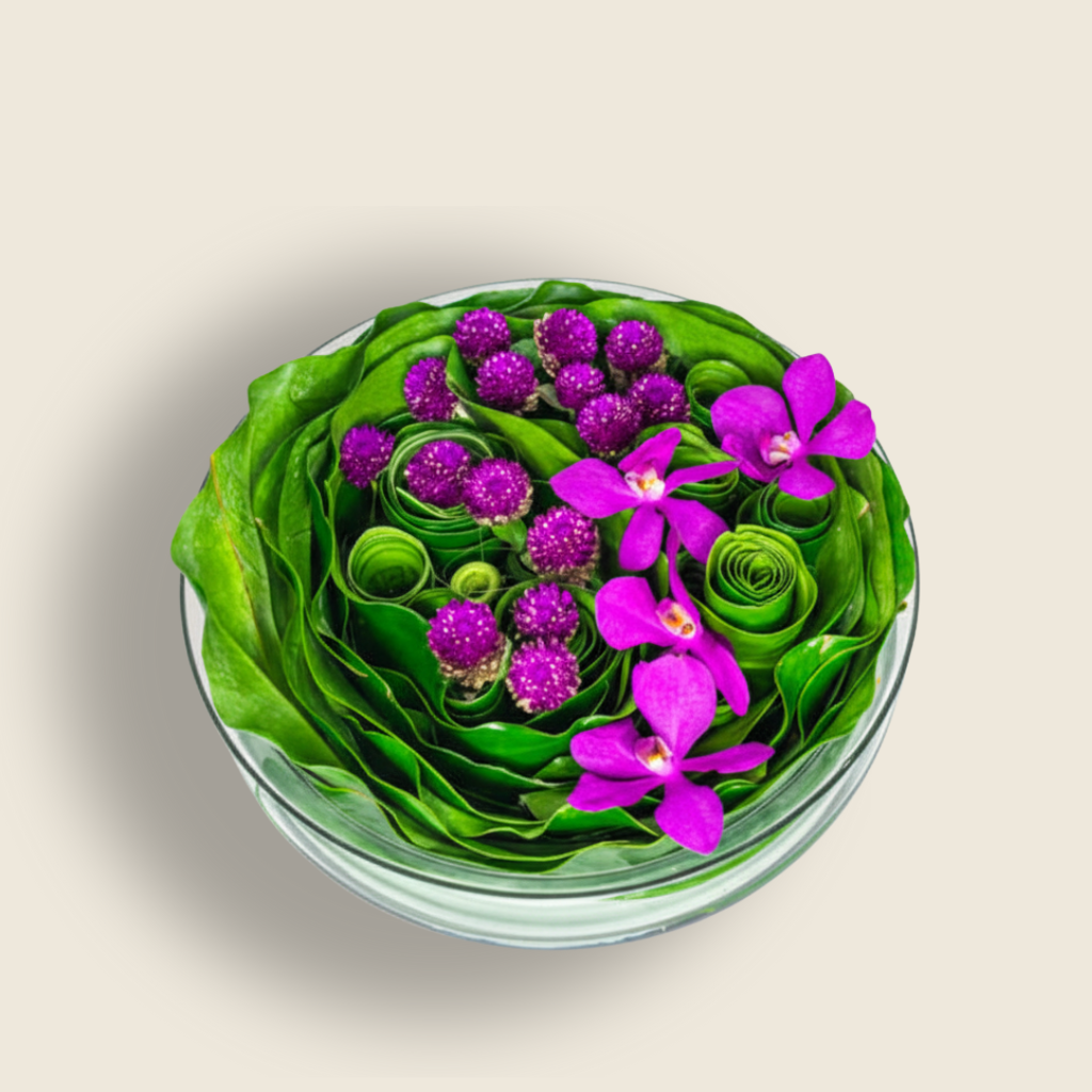 Low bowl arrangement with purple orchids and gomphrena flowers