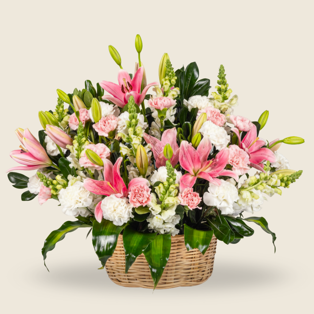 Pastel pink and white floral basket arrangement with lilies and carnations